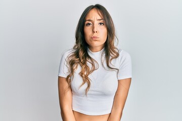 Obraz premium Young brunette woman wearing casual white t shirt showing and pointing up with fingers number ten while smiling confident and happy.