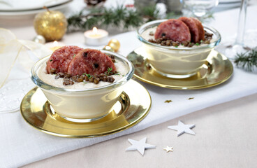 Fette di cotechino con crema di lenticchie servito su piatto. Decorazioni natalizie. Cibo italiano.