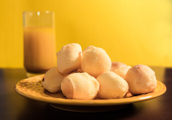 Cheese buns in yellow plate. Brazilian cheese bread on yellow background.