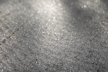 Ice and frost background on frozen glass. Colored in silver or grey tone. Selective focus at center with blur edges of image