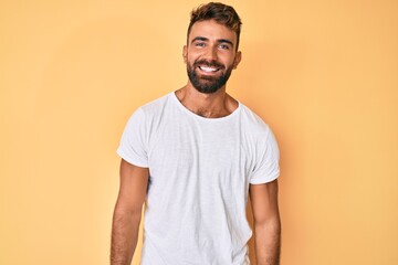 Young hispanic man wearing casual clothes looking positive and happy standing and smiling with a confident smile showing teeth