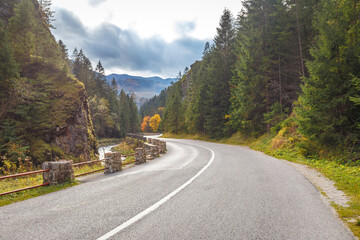 Fototapeta premium Road through a rocky gorge in a mountain valley at autumn. The Vratna valley in Mala Fatra national park, Slovakia, Europe.