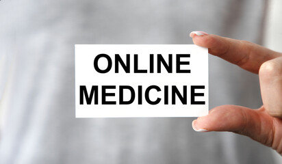 The girl holds a business card in front of her with the text ONLINE MEDICINE.