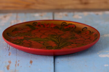 round painted dish on old wooden background