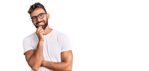 Young hispanic man wearing casual clothes and glasses looking confident at the camera smiling with...