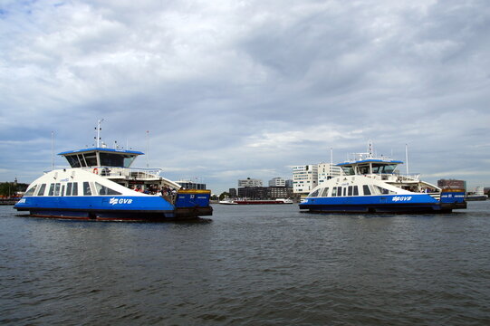 Amsterdam, North Holland, The Netherlands - August 29, 2015: Two Amsterdam passenger farries passing by in IJ harbor.