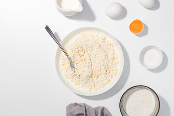 Step-by-step recipe - Cottage cheese, eggs, cream and yougurt on a white table - Flat lay