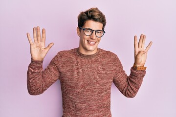 Handsome caucasian man wearing casual sweater and glasses showing and pointing up with fingers...