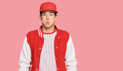 Handsome caucasian man wearing baseball uniform puffing cheeks with funny face. mouth inflated with air, crazy expression.
