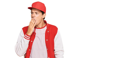 Handsome caucasian man wearing baseball uniform bored yawning tired covering mouth with hand. restless and sleepiness.
