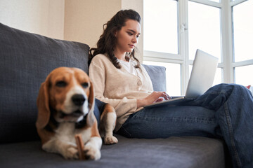 Woman sitting on sofa near dog