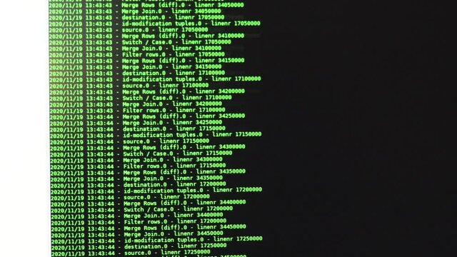Green computer software code moving on a black monitor. Computer hacking in process, dynamic text running and flowing on pc screen.