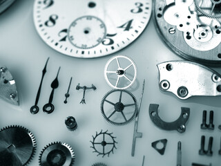 display of parts of vintage watch mechanism: dial, gears, screws, balance wheel and springs