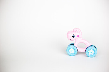 Toy rattle pink horse stands on a white background