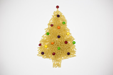 Christmas and New Year tree made of pasta sweets on a white background, free space for text - holidays, winter, the concept of Christmas and New Year