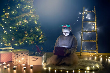 Happy little smiling girl with magic christmas gift box.