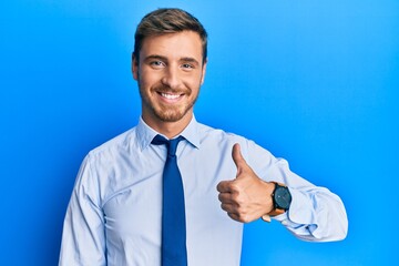 Handsome caucasian man wearing business shirt and tie smiling happy and positive, thumb up doing...