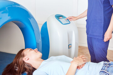 Magnet therapy system or Magnetic resonance imaging machine. Patient with doctor in medical office.