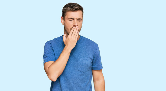 Handsome caucasian man wearing casual clothes bored yawning tired covering mouth with hand. restless and sleepiness.