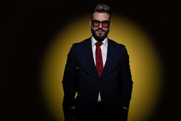 Fototapeta premium smiling businessman in navy blue suit holding hand in pockets