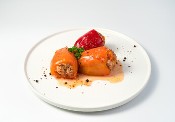 Dish with stewed bell pepper, herbs and seasonings on a white background. Side view, close-up. The concept of cooking.