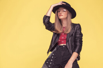 fashion model adjusting her hat, wearing a cool leather jacket