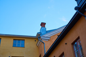 Roofs and pipes of colored rhinestone houses against the blue sky.