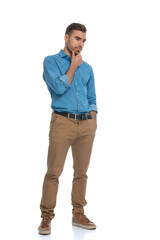 Fototapeta premium casual man touching his chin, sticking one hand in pocket