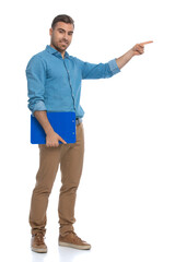 casual man pointing to a side, holding a blue clipboard