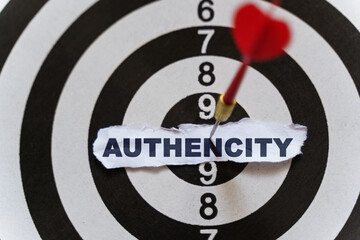 A piece of paper with the text is nailed to the target with a dart - AUTHENCITY