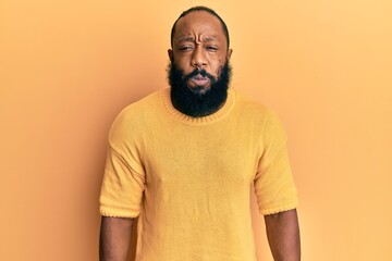 Young african american man wearing casual clothes puffing cheeks with funny face. mouth inflated with air, crazy expression.