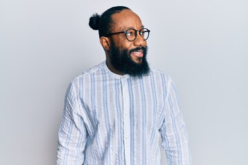 Fototapeta premium Young african american man wearing business style looking to side, relax profile pose with natural face and confident smile.