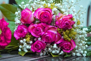 Obraz na płótnie Canvas Braut Blumenstrauß auf einem nassen Holztisch, Rosen