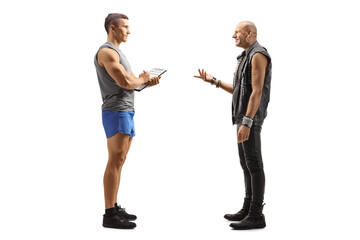 Full length profile shot of a punk man talking to a male fitness trainer