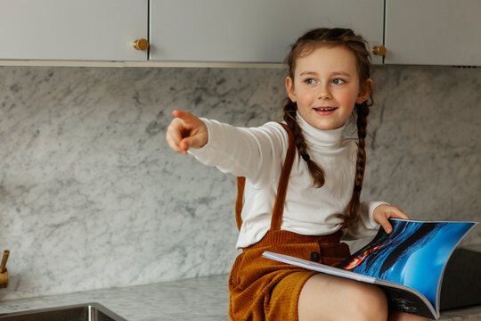 Girl Holding Book And Pointing Away, Sweden