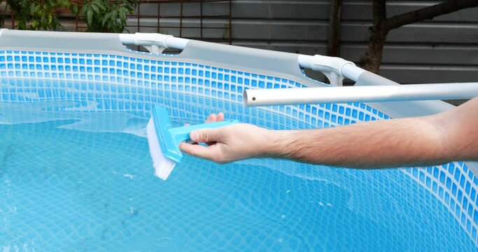 man assembling swimming pool brush, cleaning pool with a special brush.