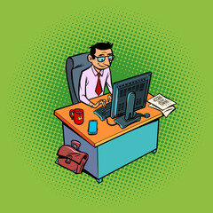 A male businessman works at an office workplace at a computer