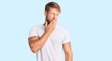 Young caucasian man wearing casual white tshirt bored yawning tired covering mouth with hand. restless and sleepiness.