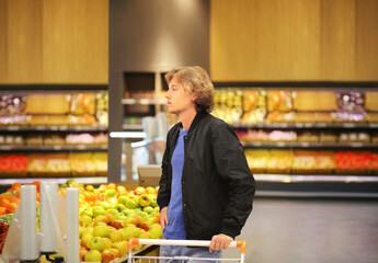 Young man buying vegetables  and fruits at the market