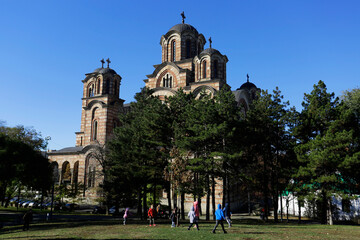 Children play in front of St. Mark's orthodox church at Tasmajdan park, during a sunny autumn day in Belgrade, Serbia.