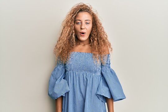 Beautiful caucasian teenager girl wearing summer dress scared and amazed with open mouth for surprise, disbelief face