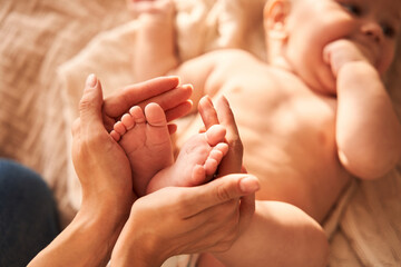 Mother holding legs of her little newborn