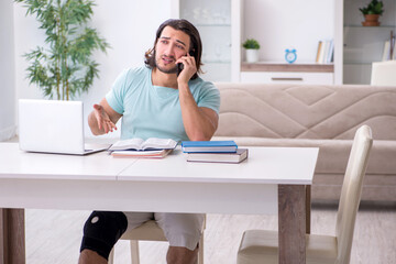 Young leg injured student studying at home