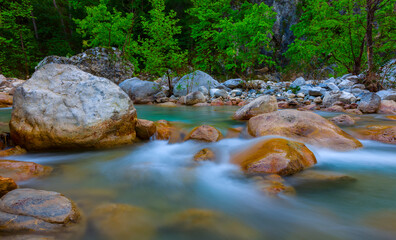 Naklejka na ściany i meble small river rushing over a stones in a mountain canyon