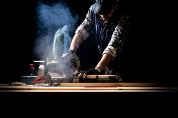 Carpenter working on woodworking machines in carpentry shop