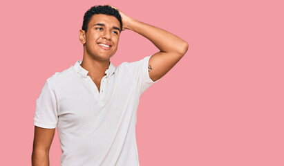 Young arab man wearing casual clothes smiling confident touching hair with hand up gesture, posing attractive and fashionable