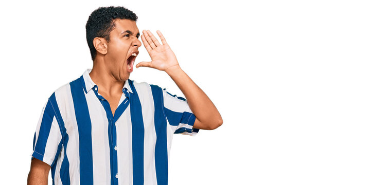 Young arab man wearing casual clothes shouting and screaming loud to side with hand on mouth. communication concept.
