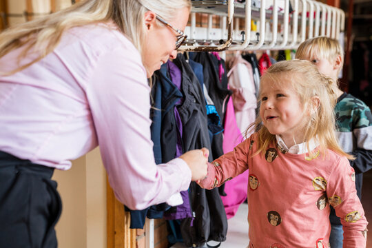 Teacher greeting children, Sweden
