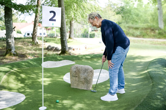 Woman playing mini golf, Sweden
