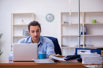 Young male employee suffering at workplace